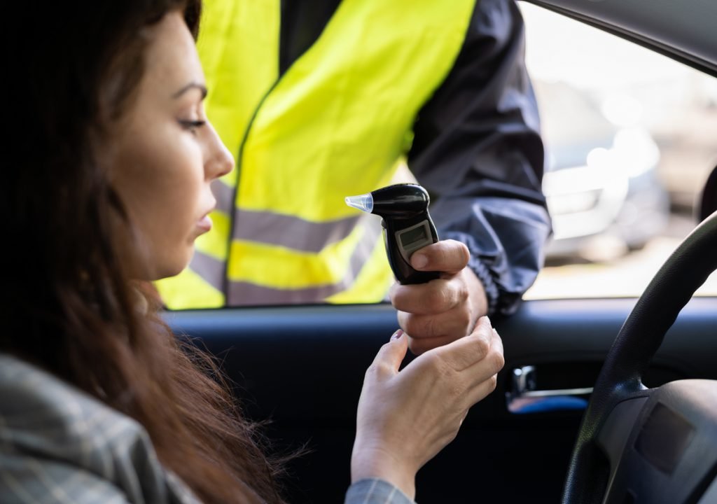Policeman Doing Driver Alcohol Test Policeman Doing Driver Alcohol Test Using Breathalyzer